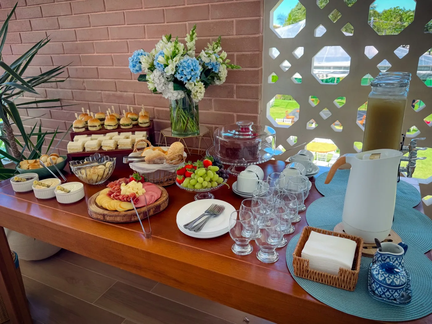 Mesa de brunch do Mirante Singular com pães, frutas, frios, bolos e bebidas